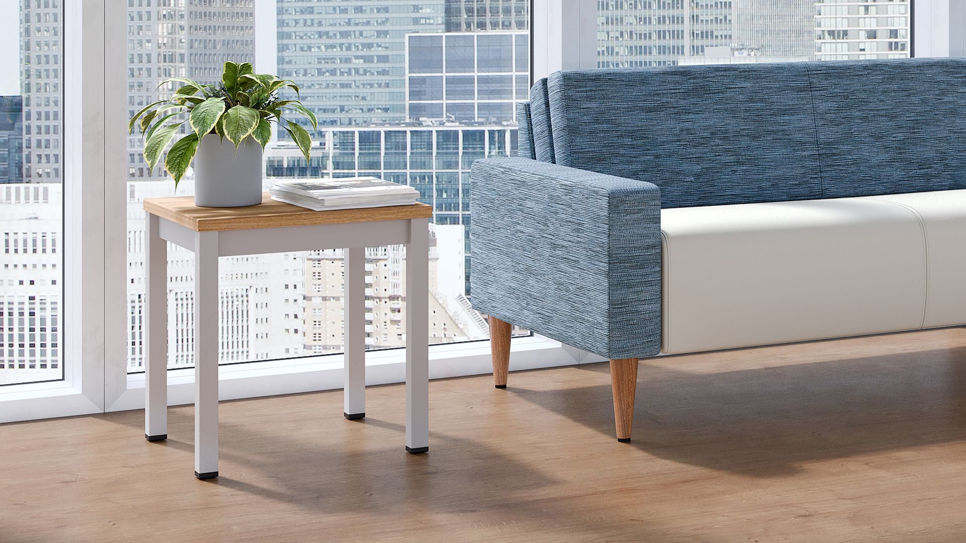 A living room with a couch and a table with a plant on it.