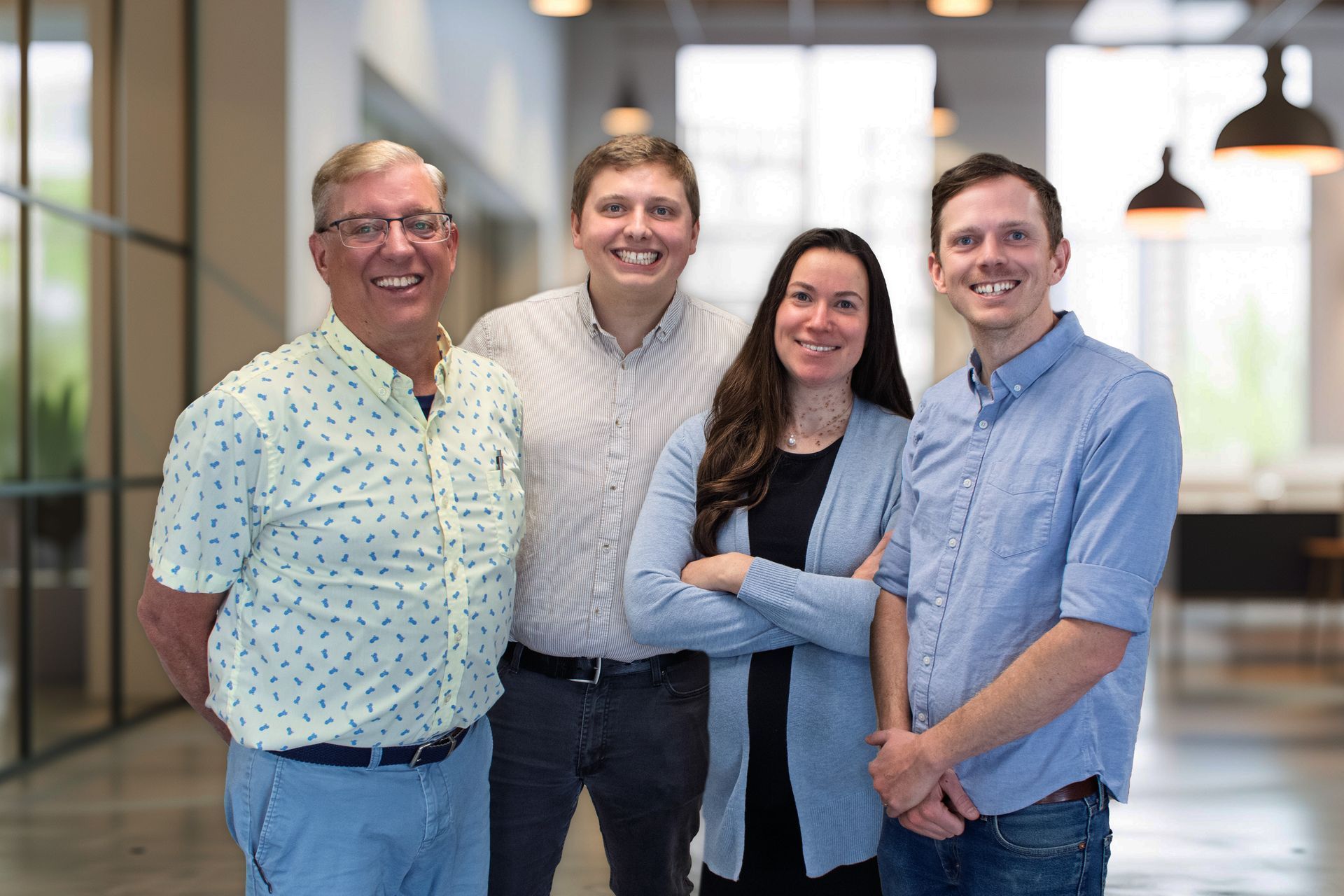 A group of people are posing for a picture in a hallway.