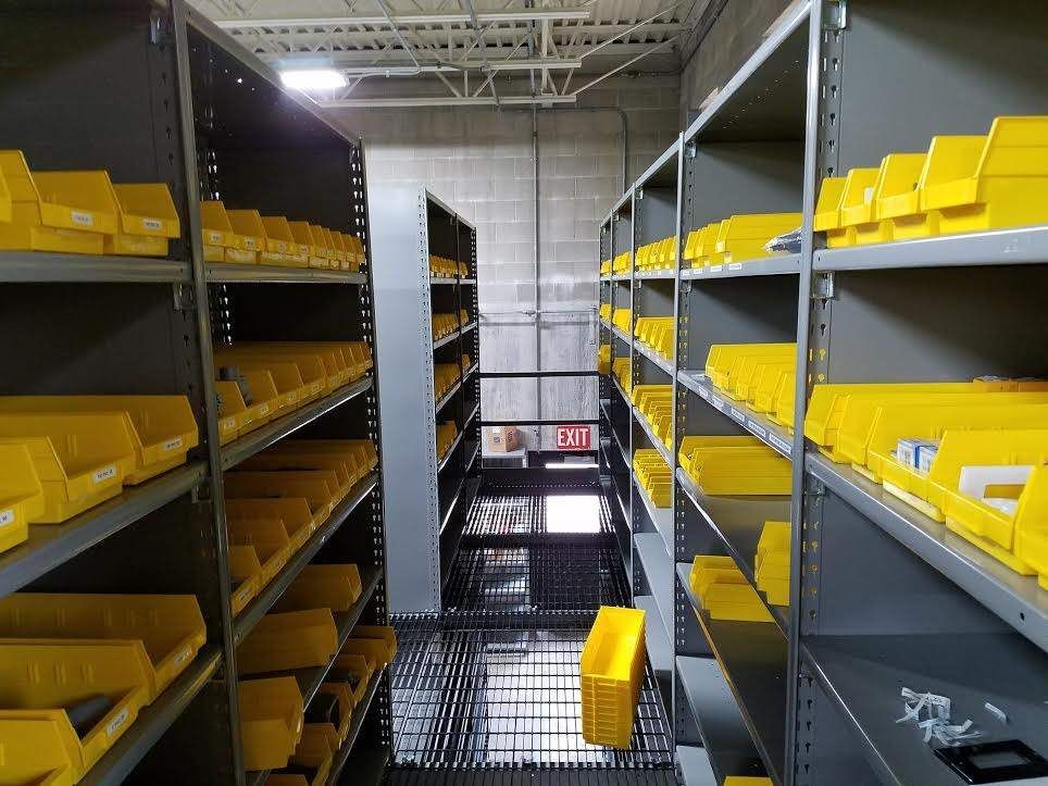 A warehouse filled with lots of yellow bins and shelves.