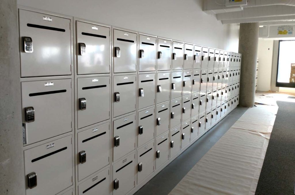 A row of white lockers are lined up on a wall.