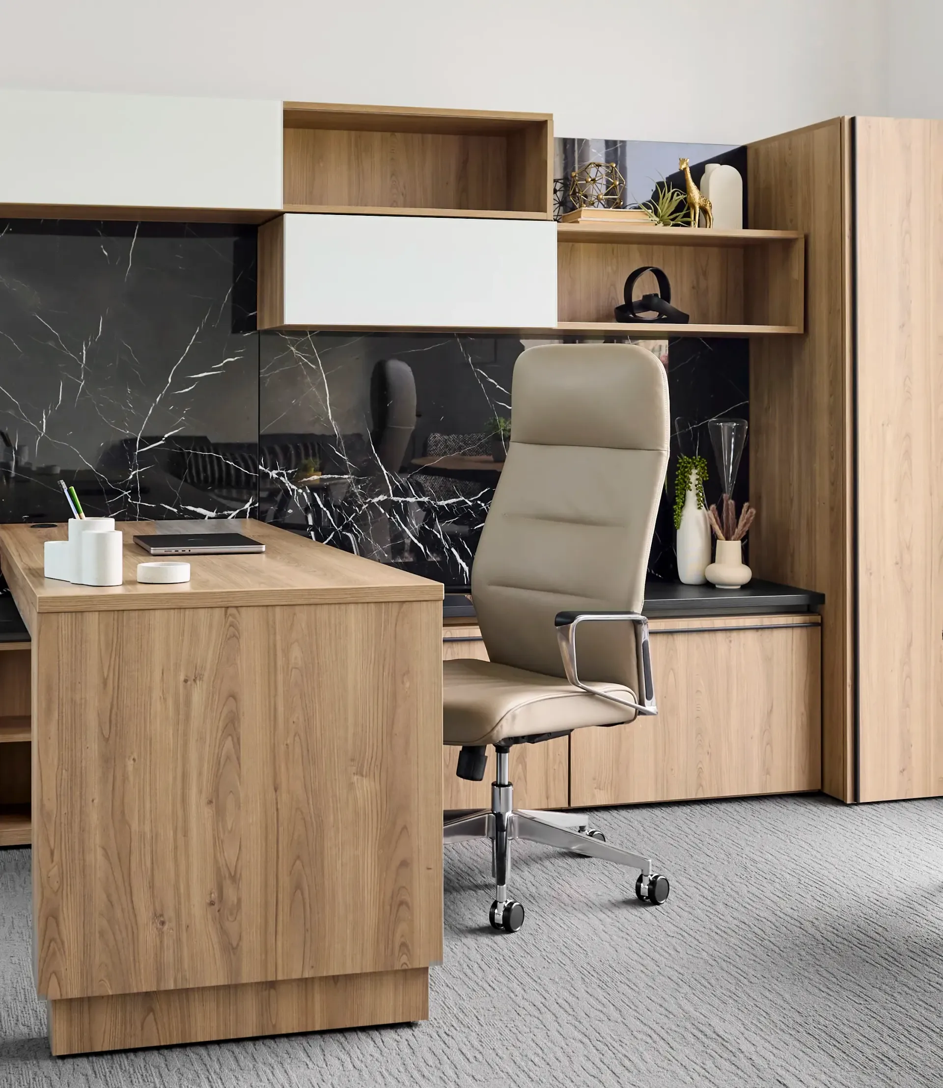 A chair is sitting in front of a wooden desk in a room.