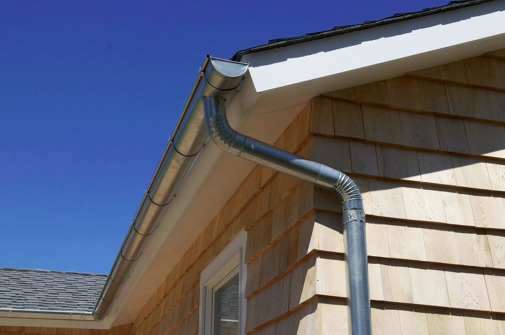 A close up of a gutter on the side of a house