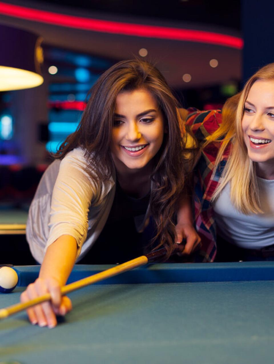 Een man en een vrouw spelen samen pool en lachen.