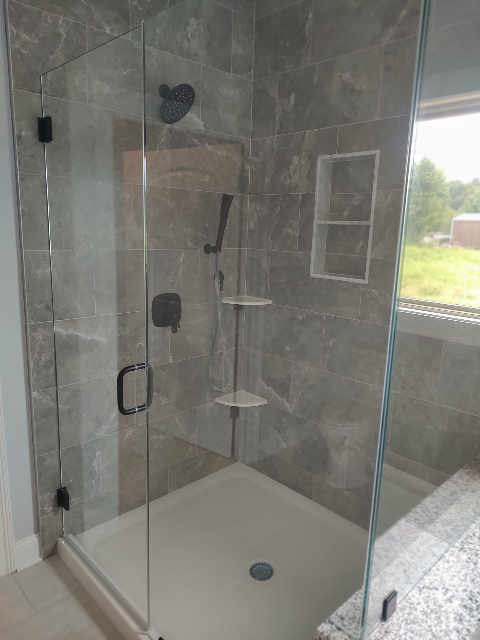 White Marey tankless water heater mounted on a wall with red, blue, and black pipes.