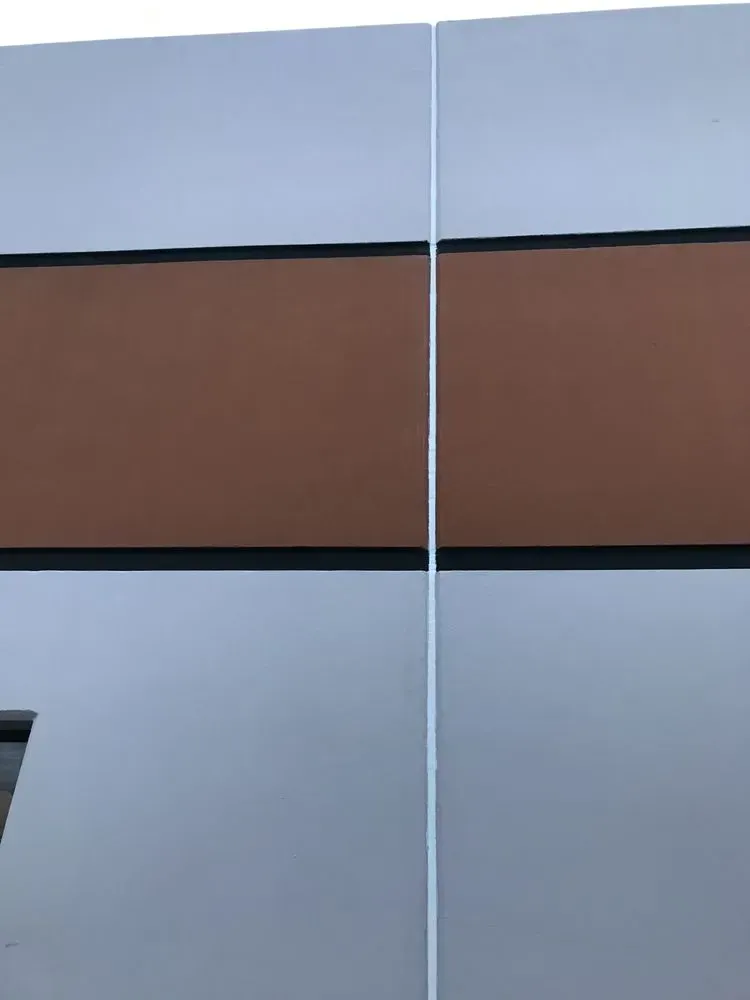 Exterior wall with horizontal panels of brown between white, vertical seam.