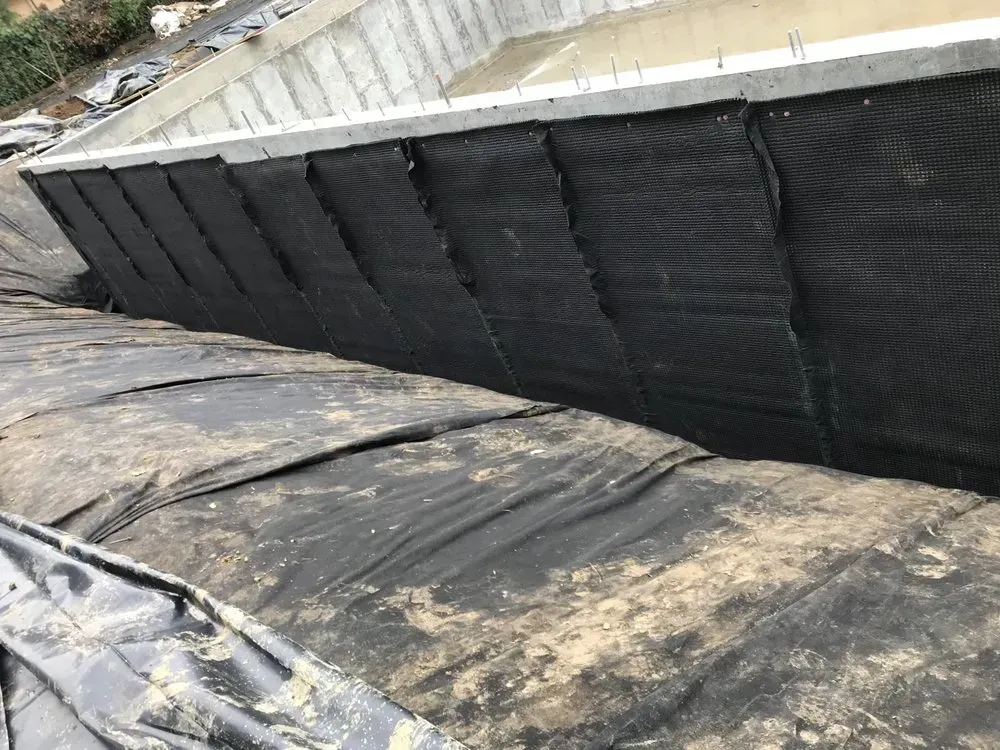 Black mesh fabric lining the interior walls of a concrete structure.