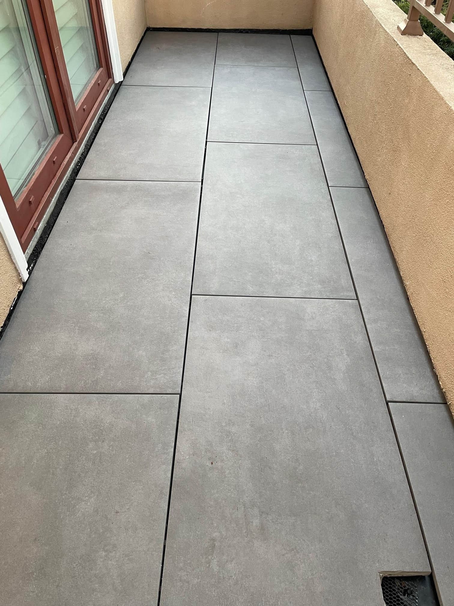Gray concrete patio with dark grout lines.