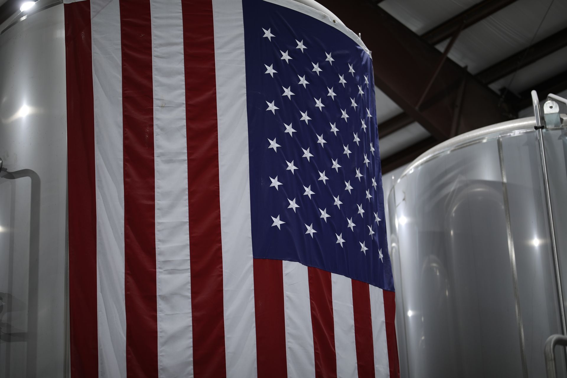 View of U.S.A flag hanging from top of fermenter tank at Kansas Territory Brewing Co