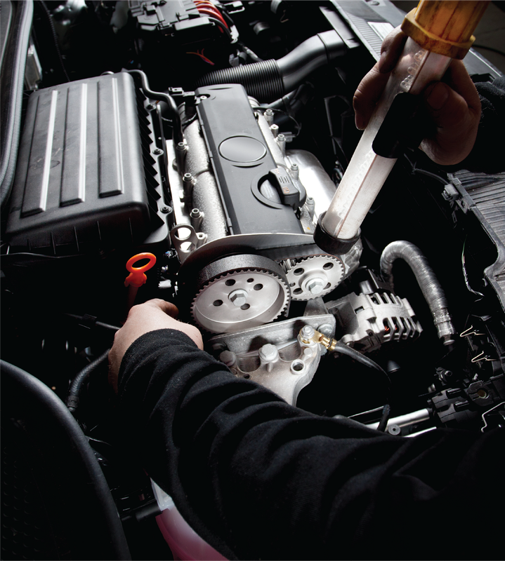 A person is working on the engine of a car