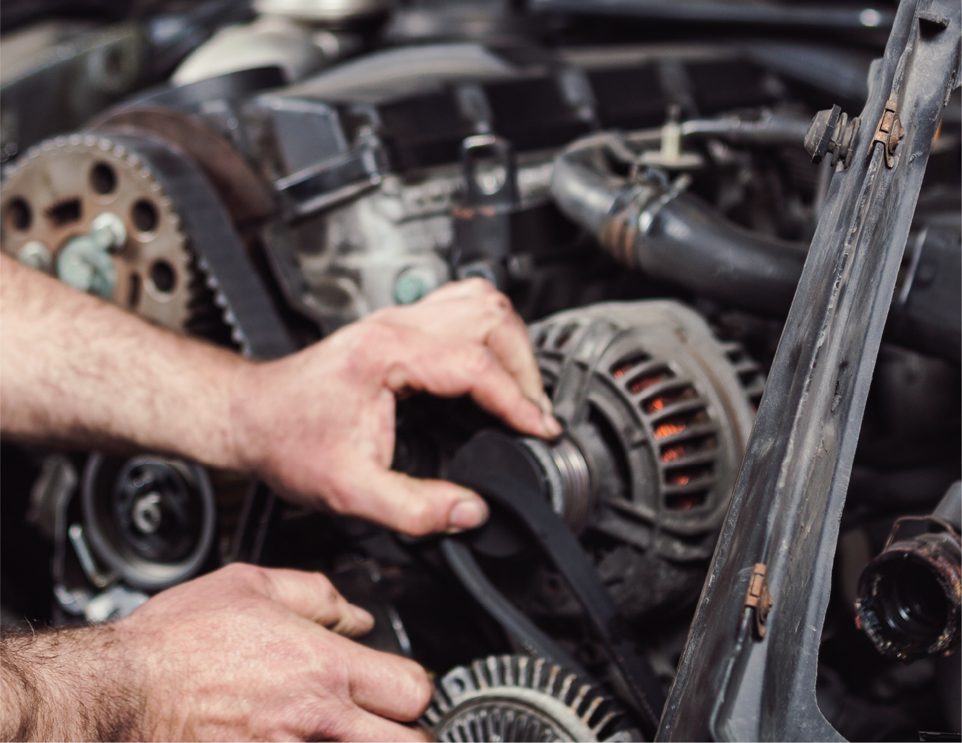 A man is working on a car engine with a wrench.