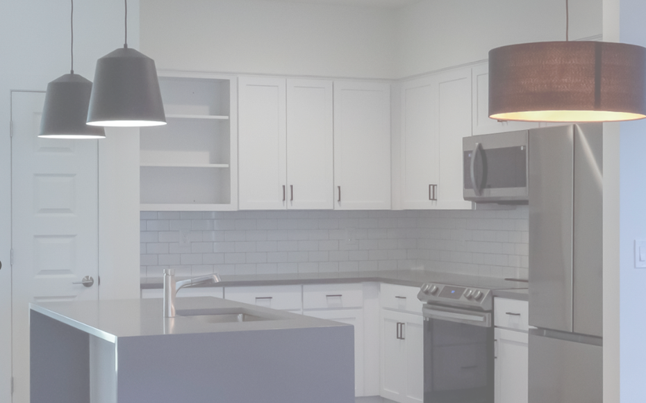 A kitchen with white cabinets and stainless steel appliances.