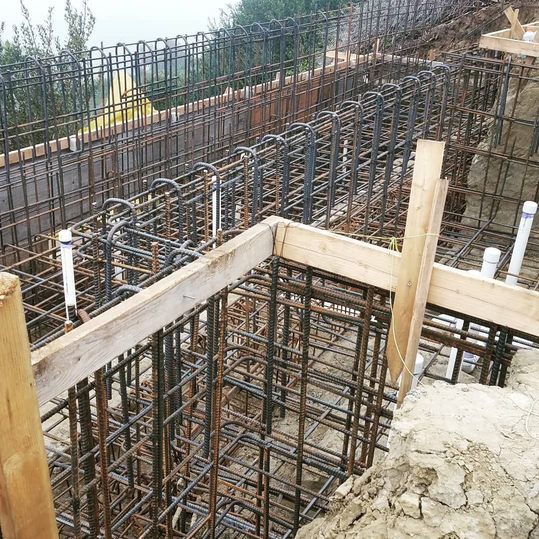 Reinforced steel bars and wooden forms for a concrete structure foundation on a construction site.