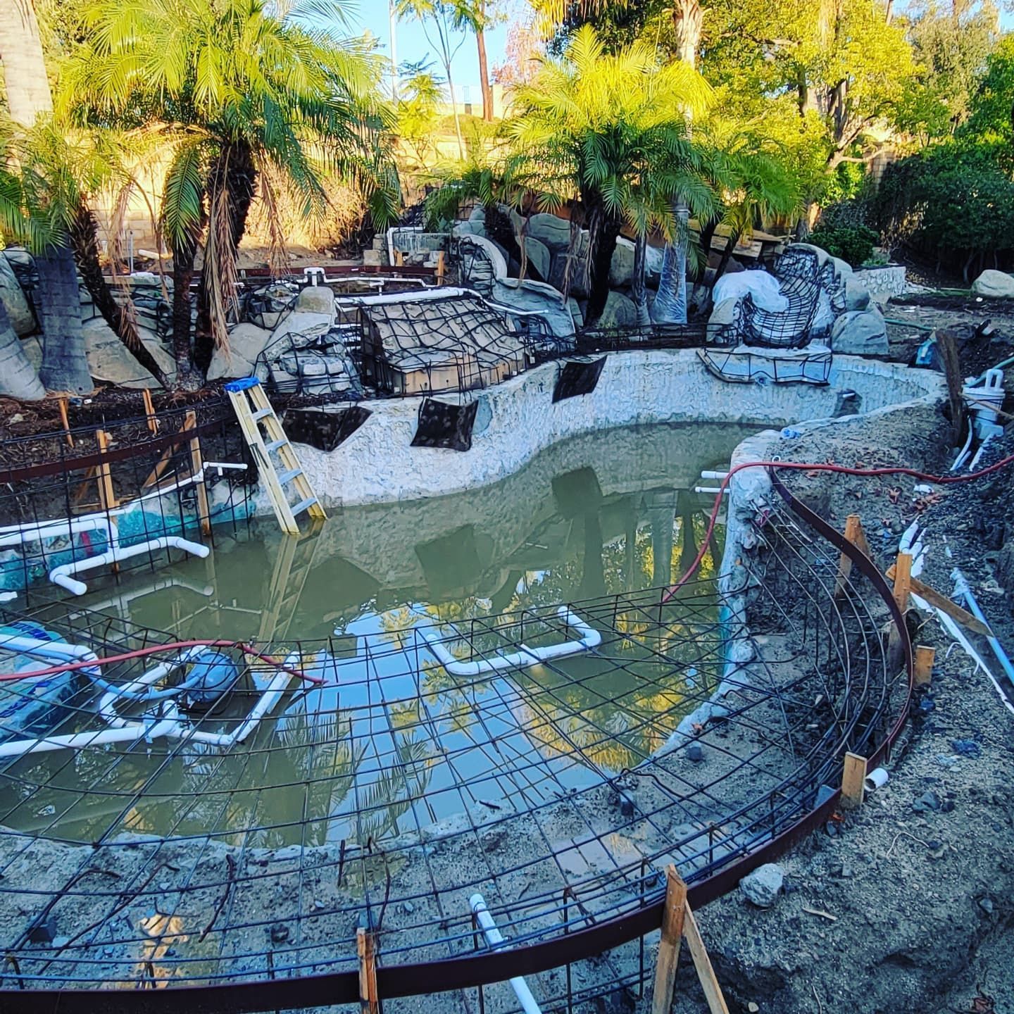 Two people inside a building under construction, examining the interior, the woman pointing.