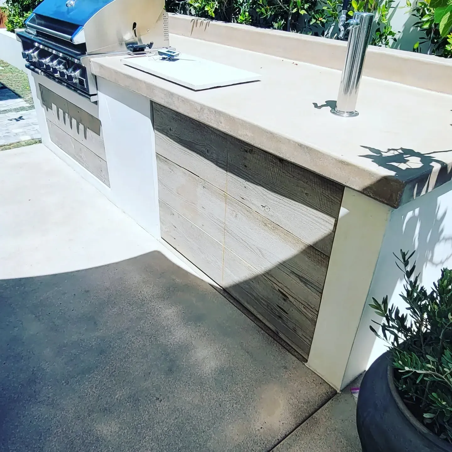 Building exterior under construction with red metal roof frame and white walls, door and windows.