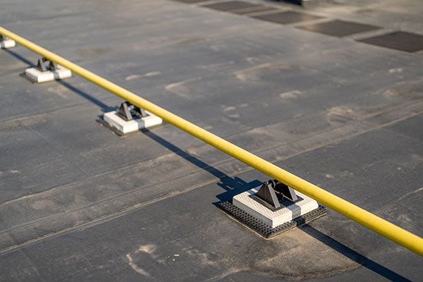 a yellow pipe is sitting on top of a black concrete surface .