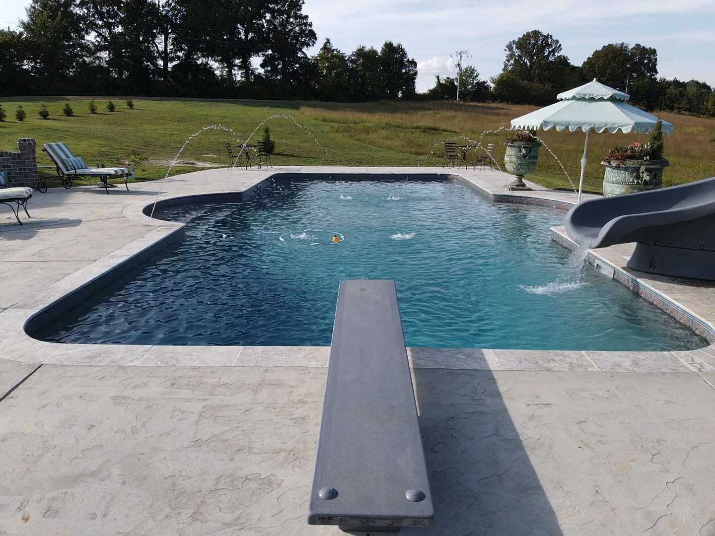 A large swimming pool with a diving board in the middle