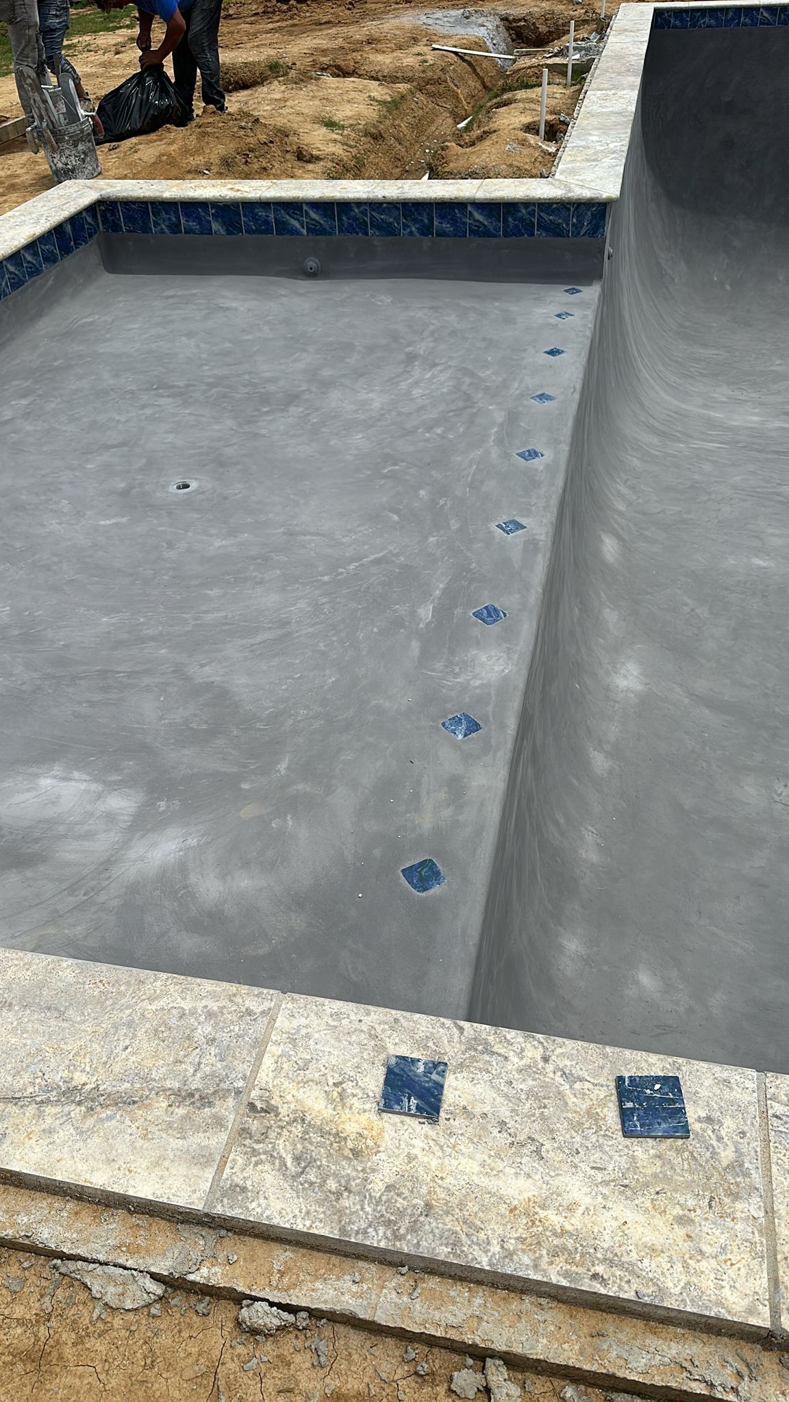 A swimming pool is being built in a backyard.