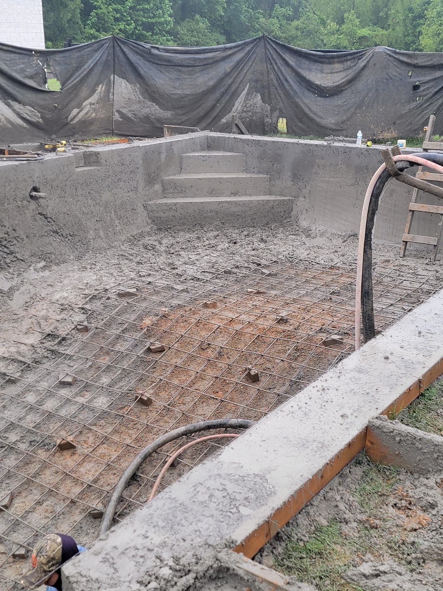 A concrete pool is being built in the dirt