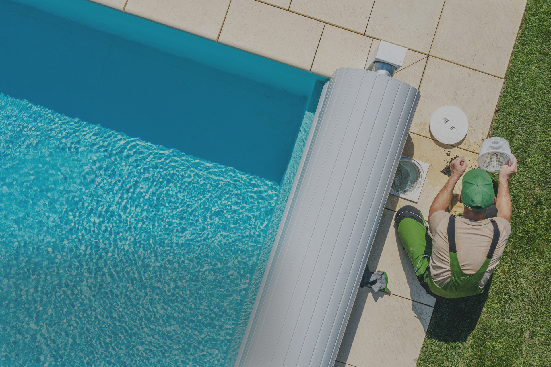 A man is sitting on the side of a swimming pool.