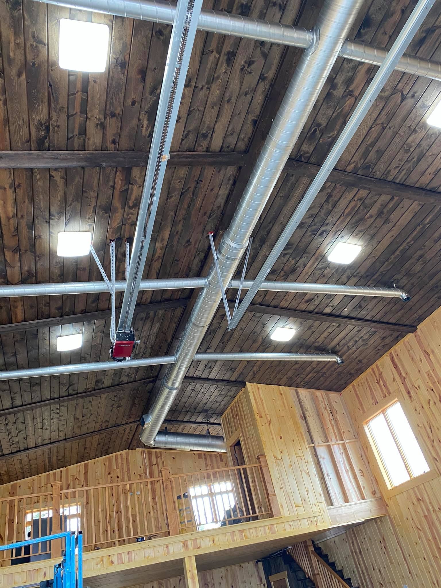 Interior view of a wooden structure. Ceiling with lights and a garage door opener. A balcony is visible below.