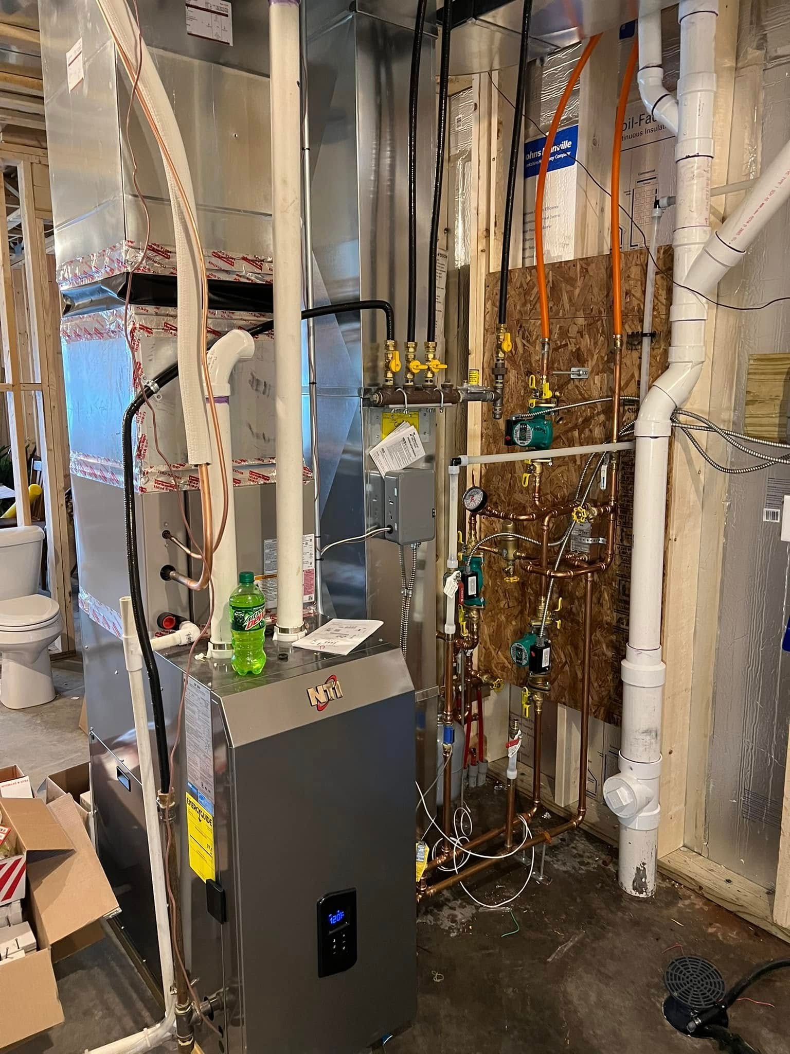 HVAC and plumbing in a new construction basement. Silver furnace, metal ductwork, copper pipes, and exposed studs.