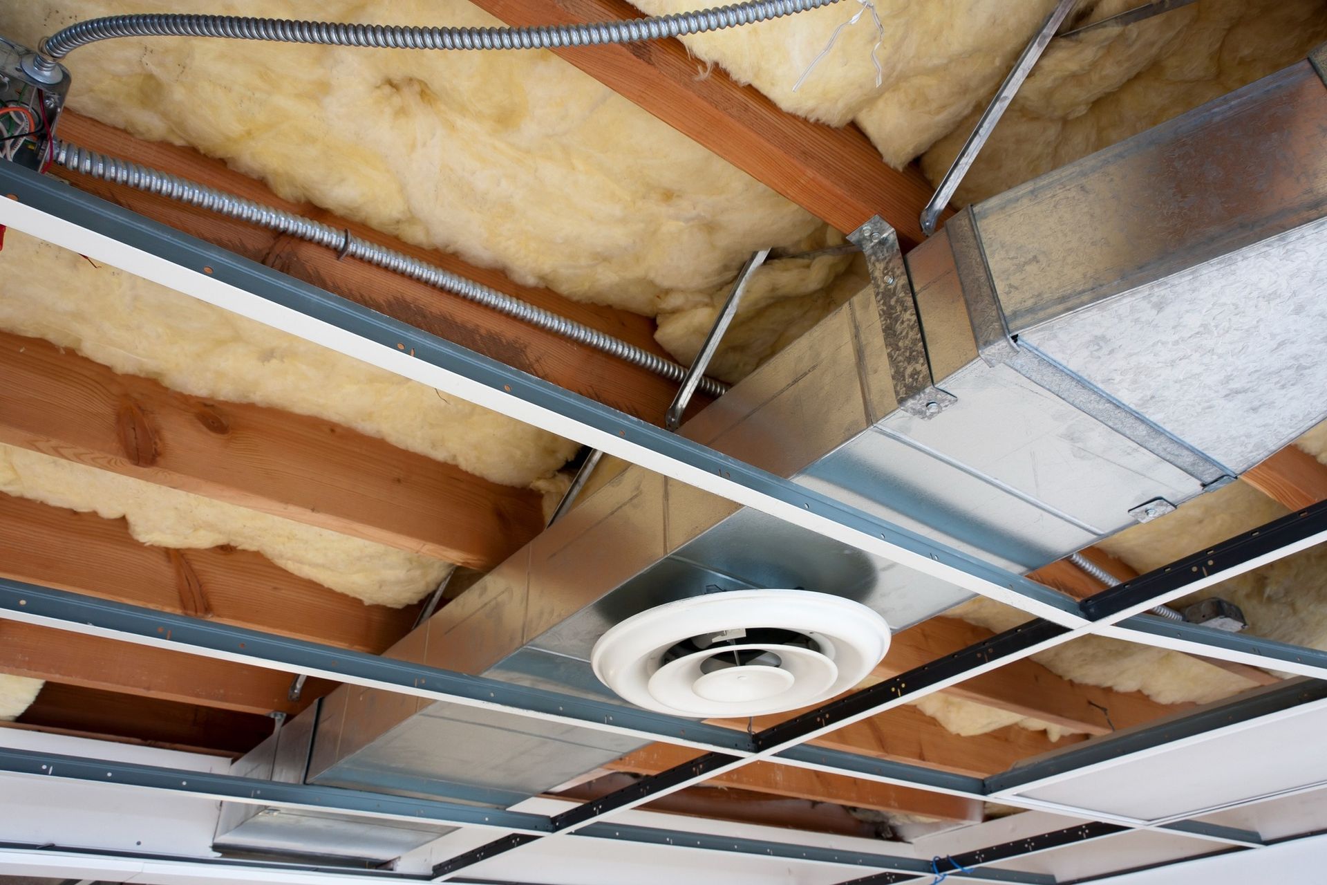 Ceiling view showing HVAC system with exposed ductwork, electrical wiring, and insulation.