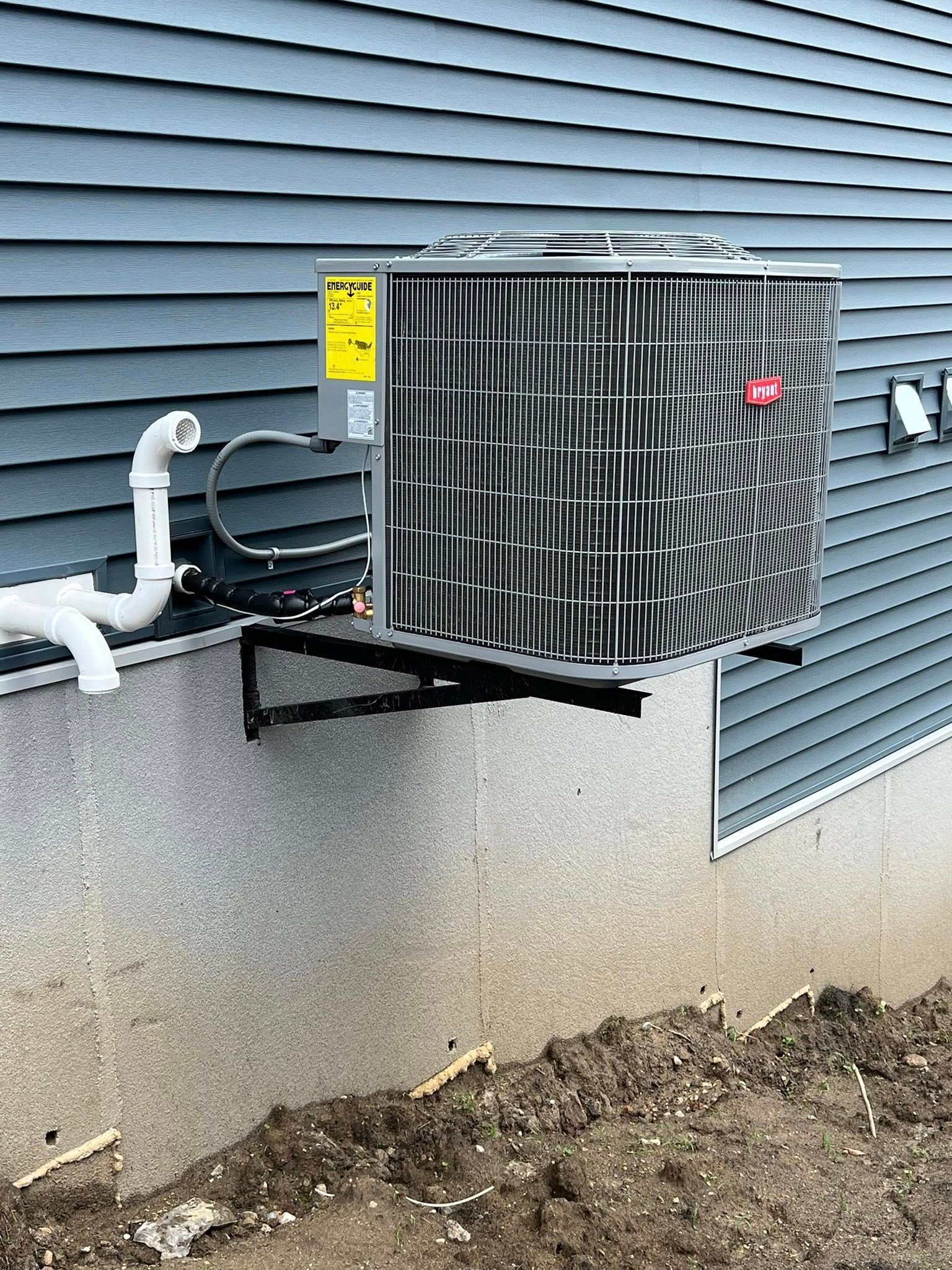 An air conditioning unit mounted on a bracket attached to a building's exterior.