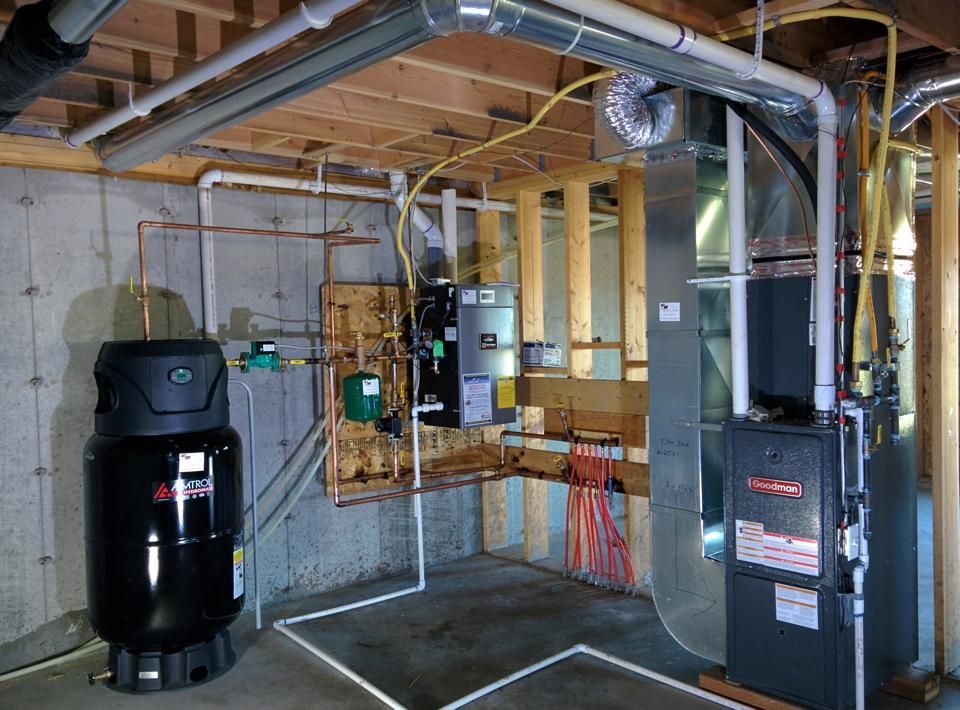 Basement with water tank, furnace, and ductwork. Piping and electrical wiring visible. Cement walls, wood framing.