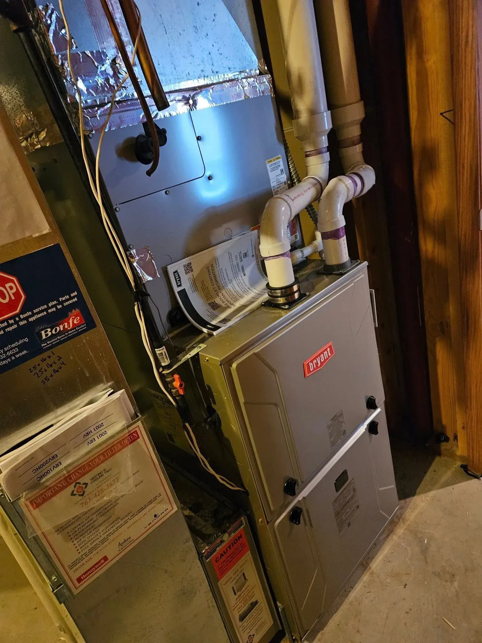 Furnace in a utility room with attached pipes and ductwork.
