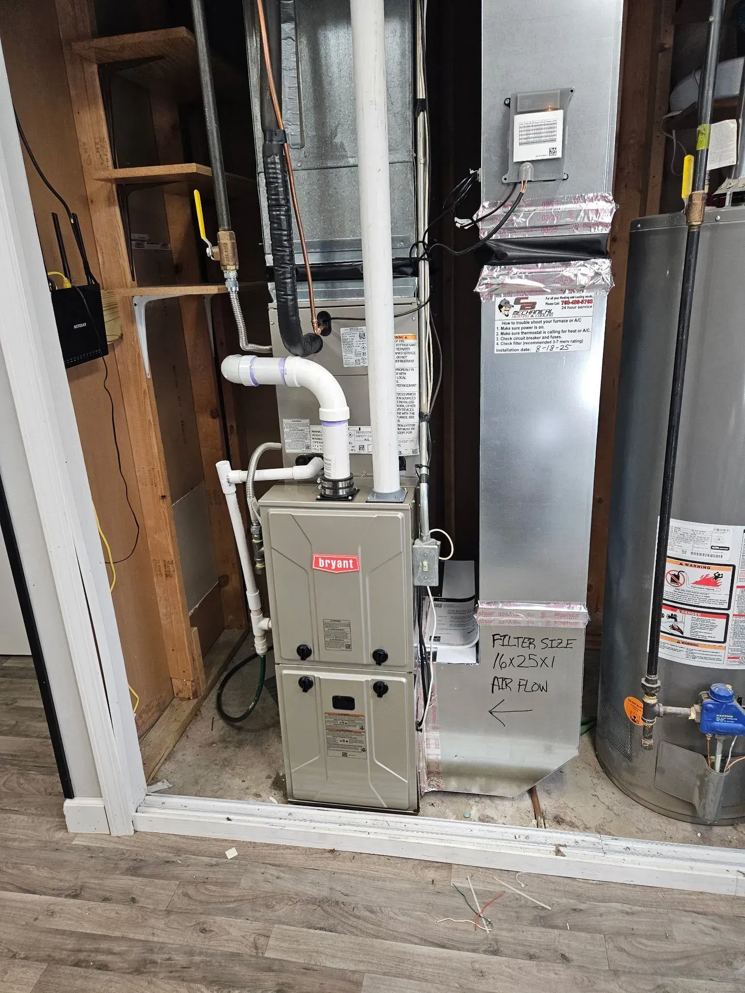 Furnace and ductwork in a utility room; a water heater is visible on the right.