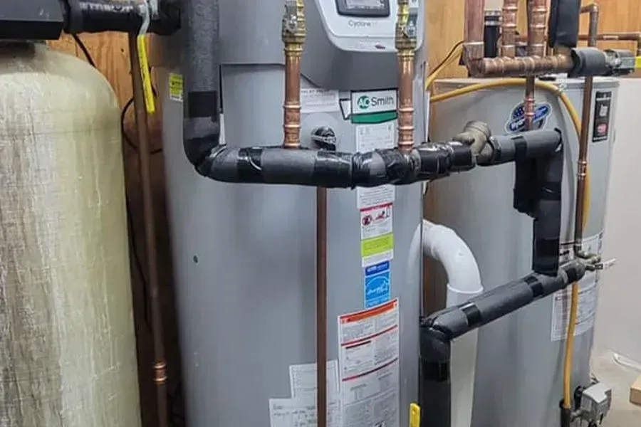 Plumbing system with water heater, pipes, and fittings in a utility room.