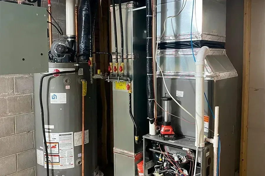Furnace, water heater, and ductwork in a basement setting.