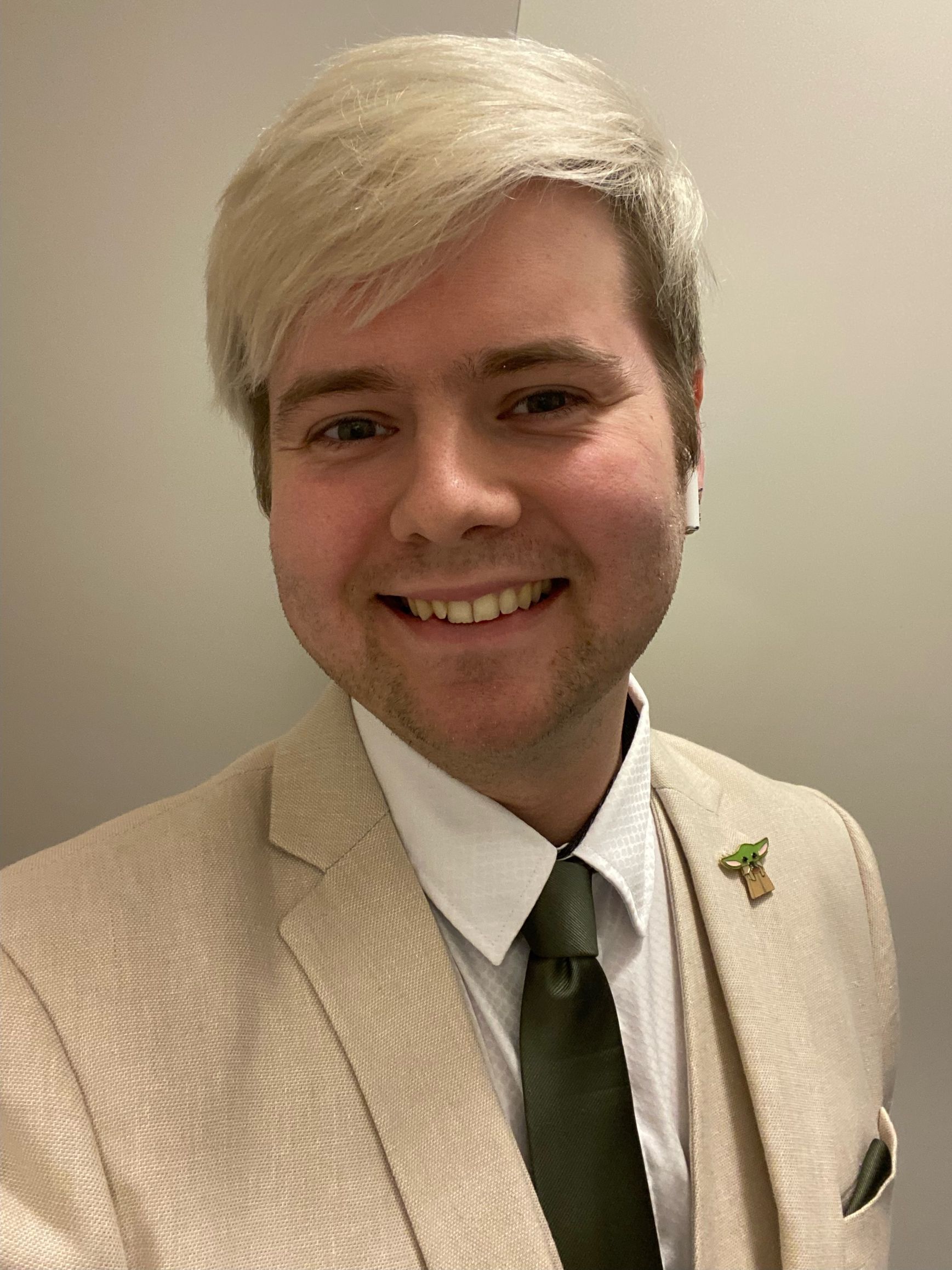 A man in a suit and tie is smiling for the camera.