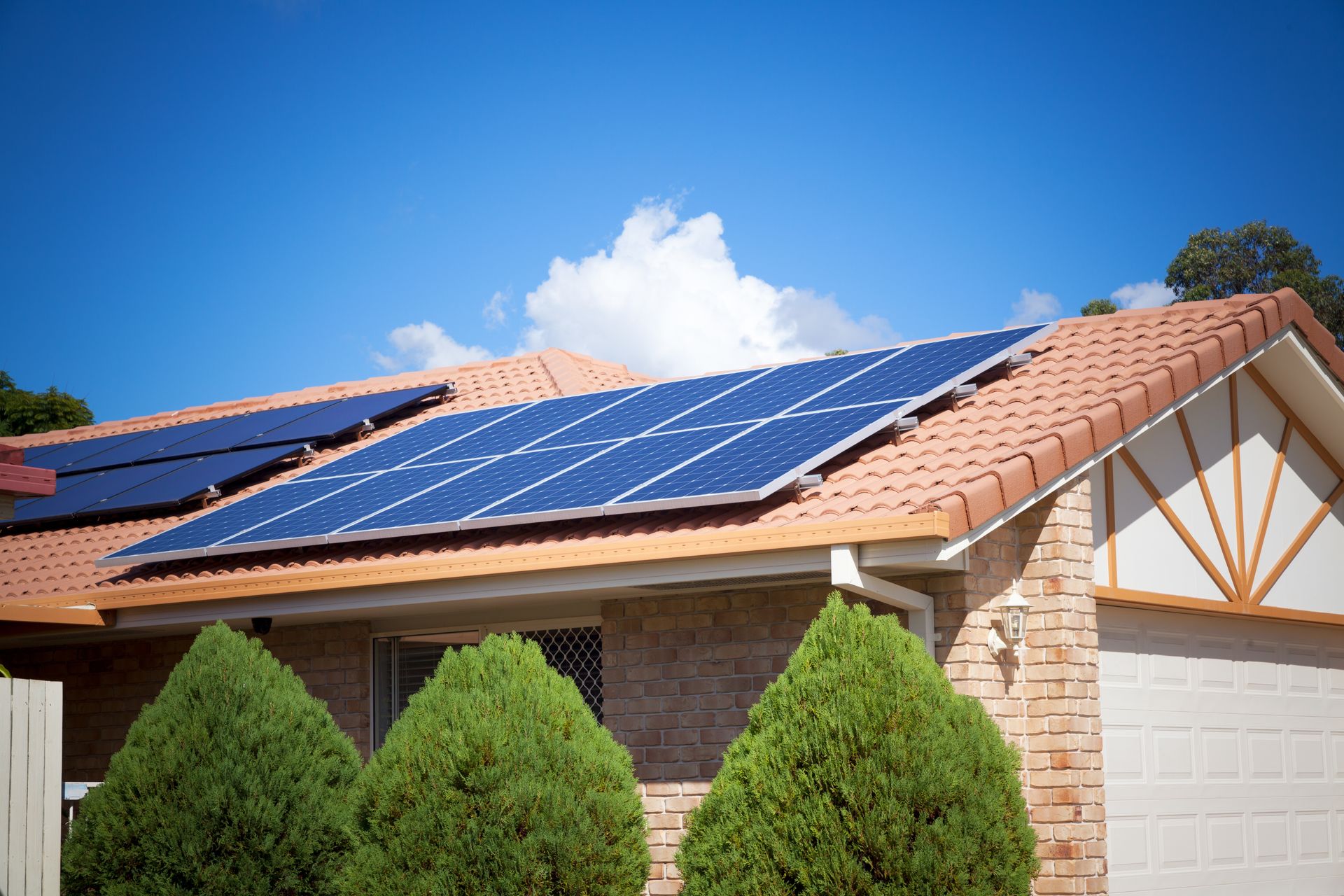 Solar panels on a residential roof under a blue sky.