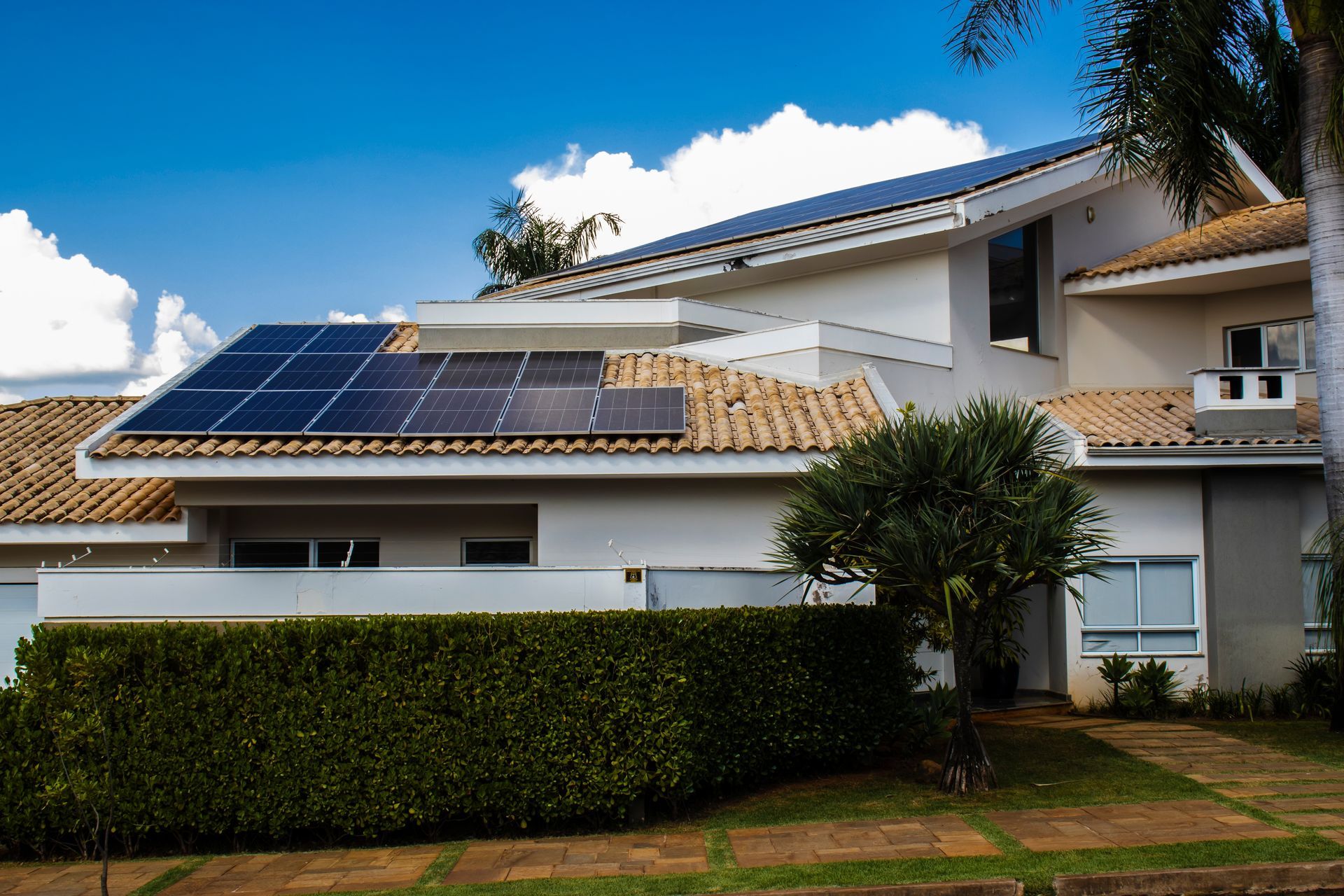 House with solar panels on roof; blue sky.