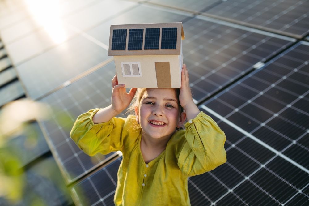 A person installing a solar panel on a gray corrugated metal roof.