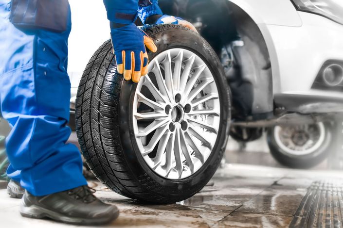 A man is changing a tire on a car.
