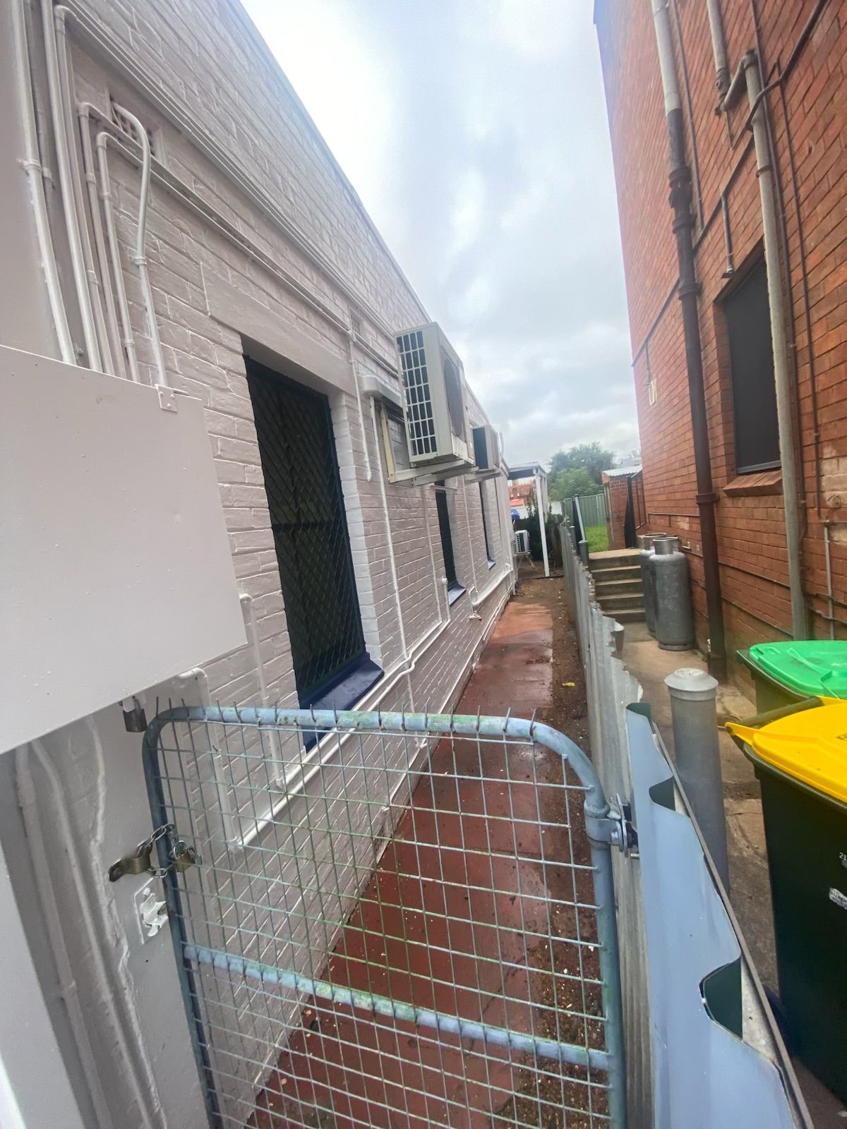 A Narrow Alleyway Between a White Brick Building and a Red Brick Wall — Robert Seeliger Painter & Decorator in Dubbo, NSW