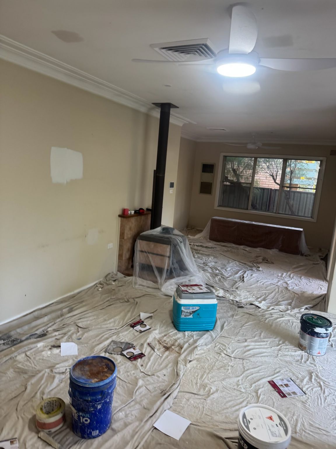 Messy Living Room Under Renovation, With Floor Covered in Drop Cloths — Robert Seeliger Painter And Decorator in Dubbo, NSW