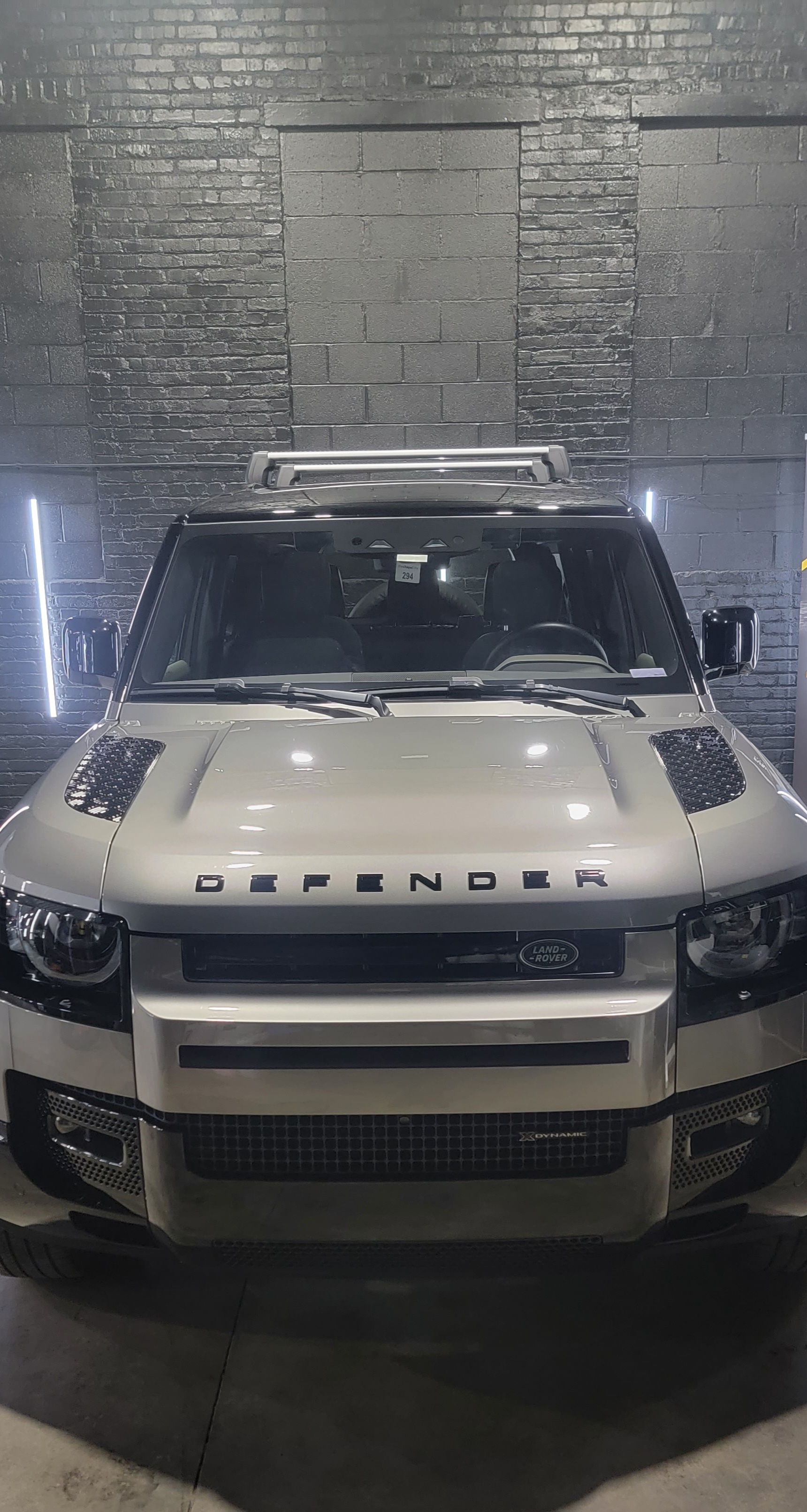 A white car with black windows is parked in a garage.