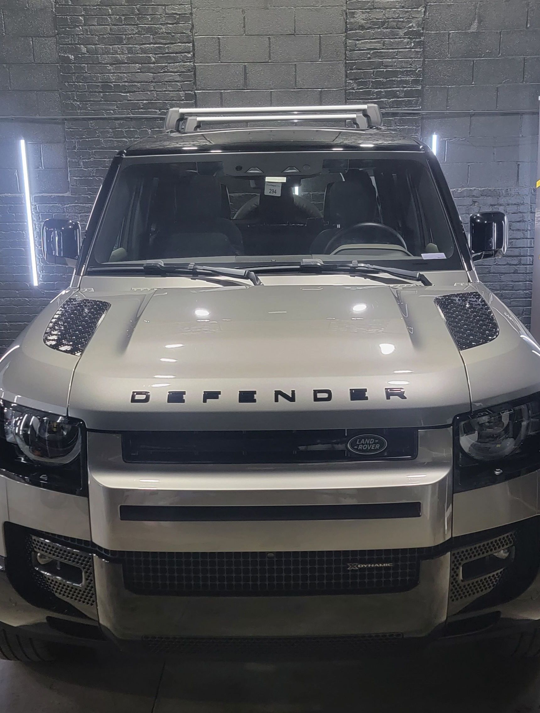 A white land rover defender is parked in a garage.