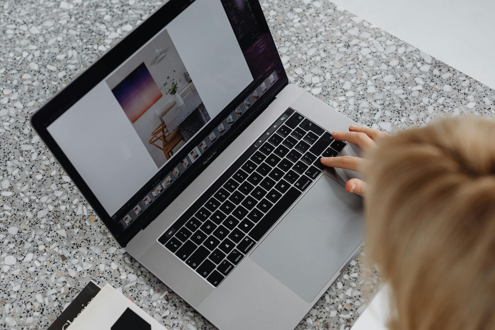 An open laptop on a grey table seen from above.