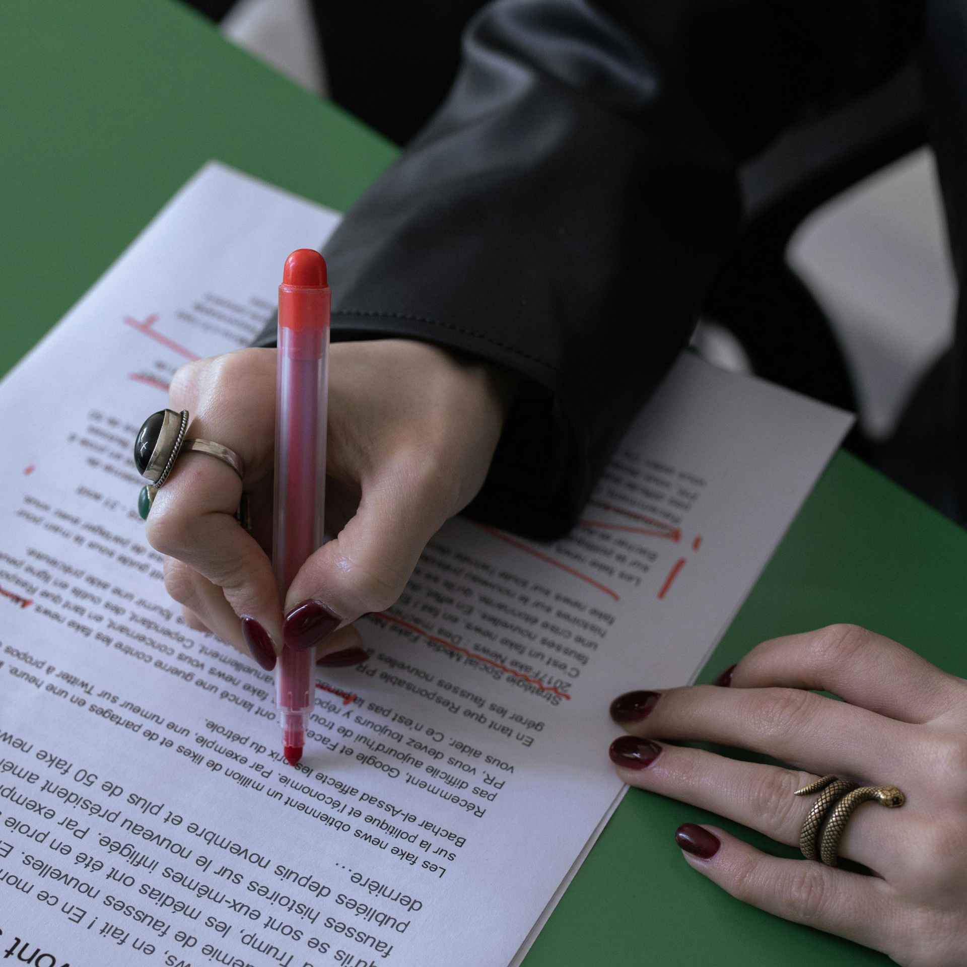 Hand writing on printed text with a red pen
