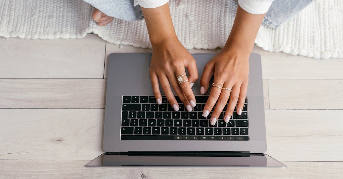 Hands typing on a laptop keyboard, as seen from above
