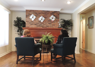 Adult Foster Care — Front Visiting Area with Inviting Fireplace in Southfield, MI