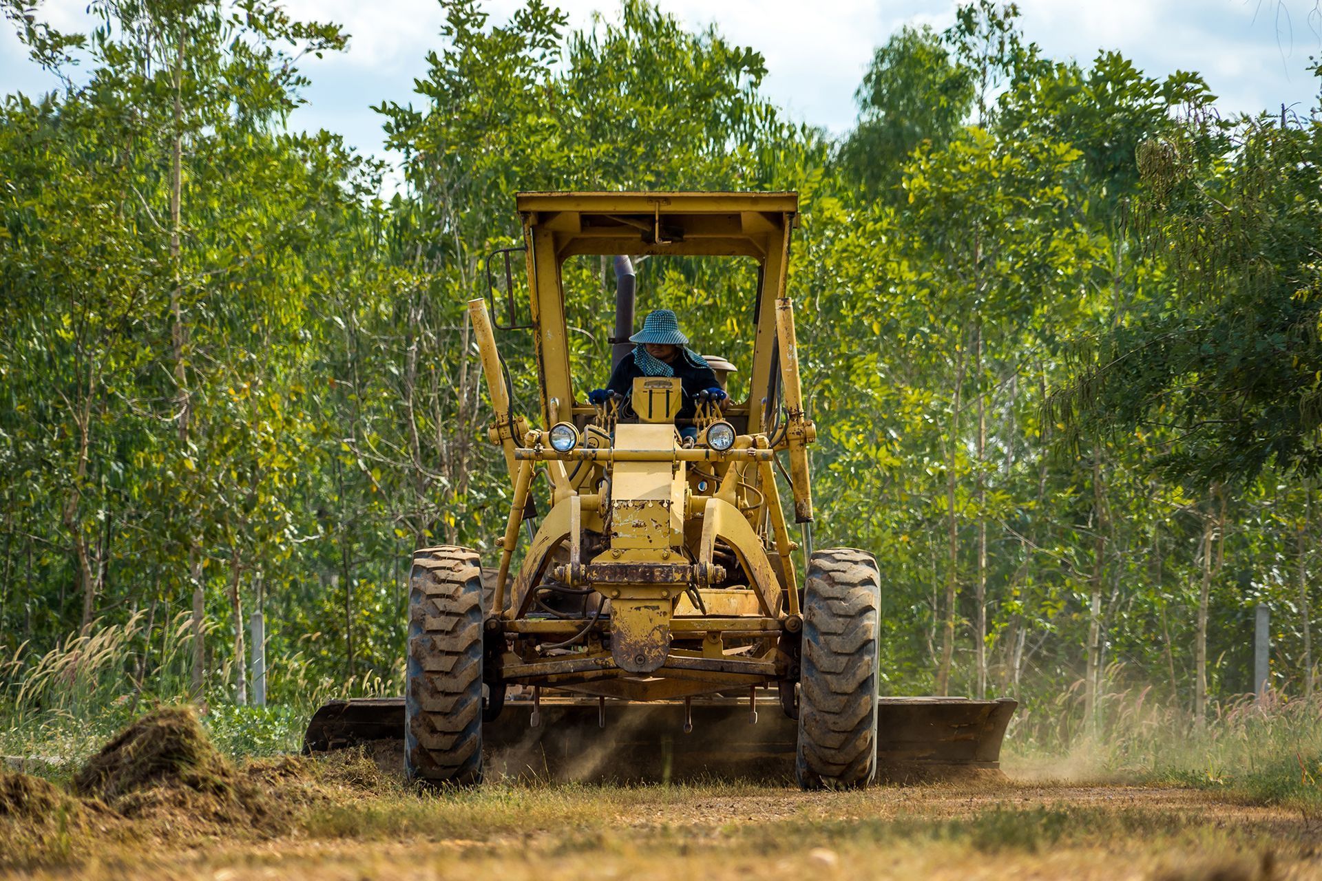A bulldozer is driving through a dirt field.