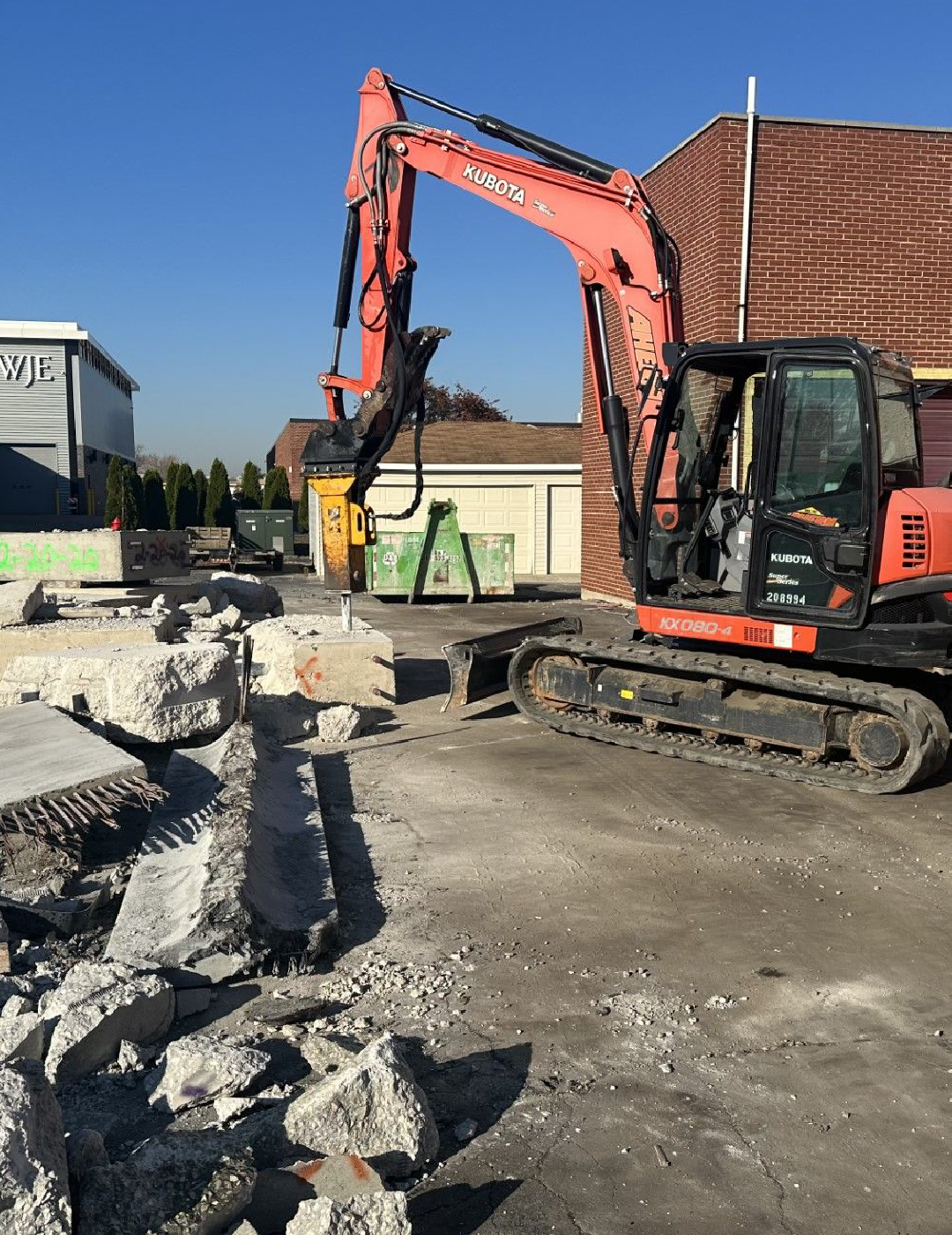 A large excavator is working on a construction site to excavate concrete