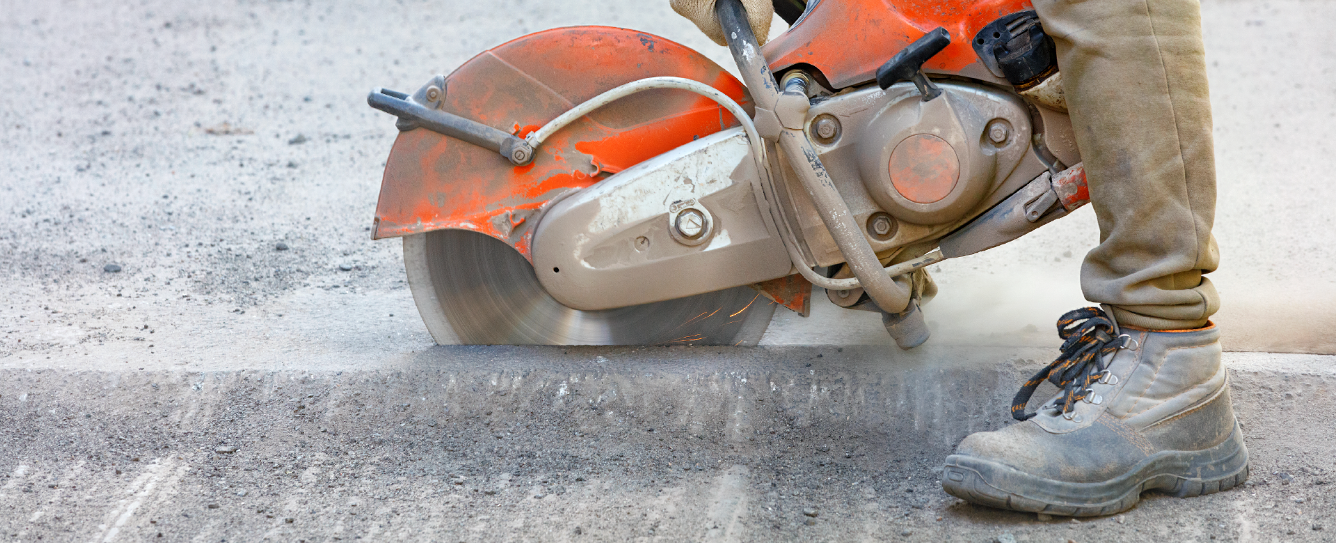 A person is cutting concrete with a circular saw.