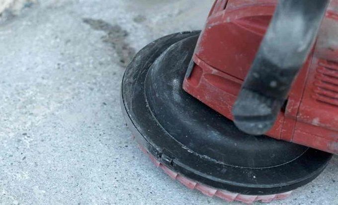 A person is using a grinder on a concrete surface.