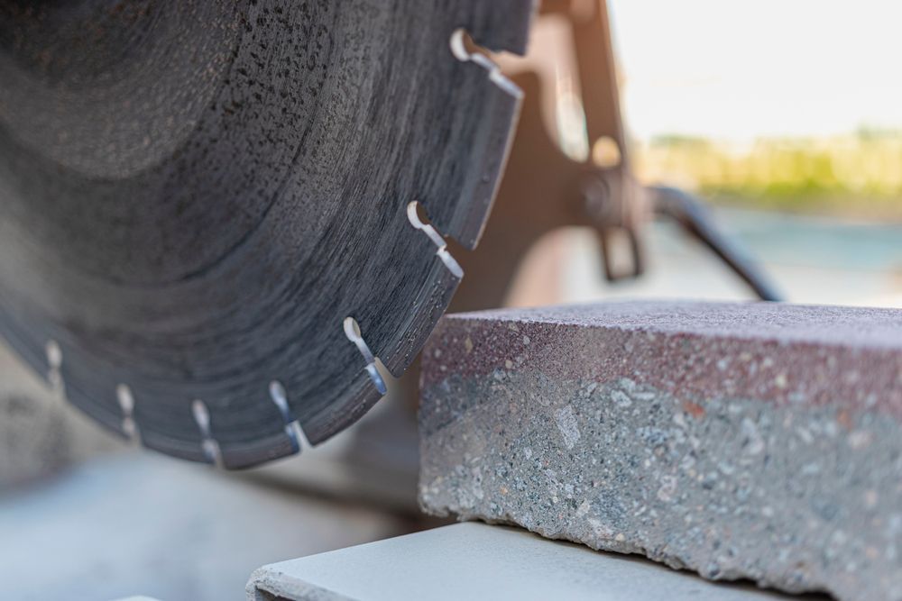 A circular saw is cutting a piece of concrete.